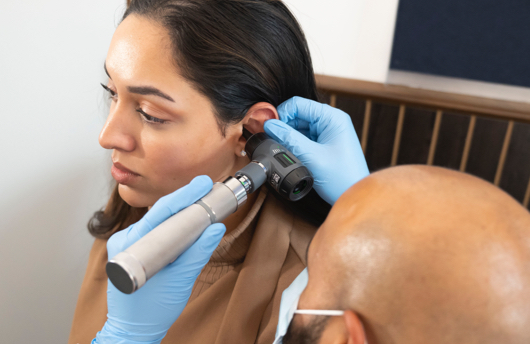 Woman getting her ear examined at Pindrop Hearing