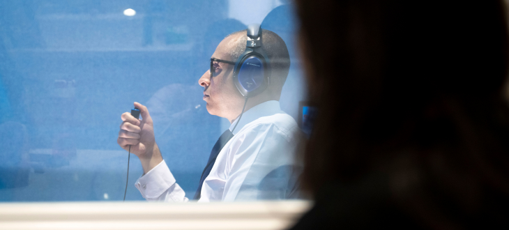 Woman performing hearing test on a man with glasses